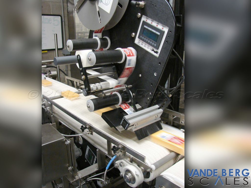 Top and Bottom Cheese Labeling System - unit applies the label at the same speed as the conveyor belt to ensure a wrinkle-free application